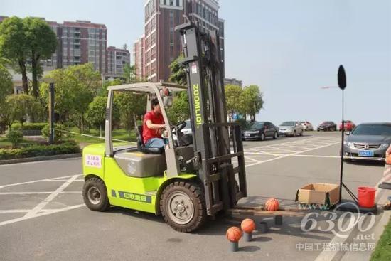 參賽選手駕駛中聯(lián)重科叉車進(jìn)行“投籃”項目