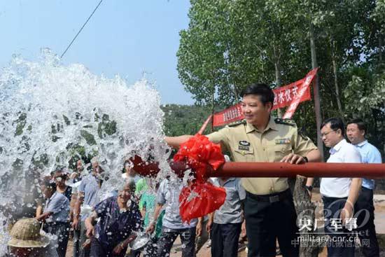 部隊(duì)領(lǐng)導(dǎo)和群眾一起為“扶貧井”出水竣工歡呼