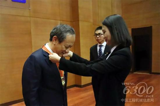 新入職管培生代表青年黨員向公司黨委書記、董事長王民授予徐工五星年功章