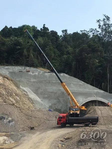 在一處隧道建設(shè)處，徐工起重機(jī)正緊張的忙碌著。