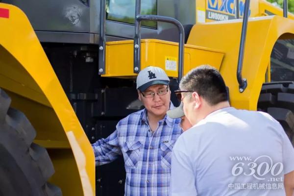 客戶仔細觀察裝載機，并不斷向工作人員詢問其性能參數